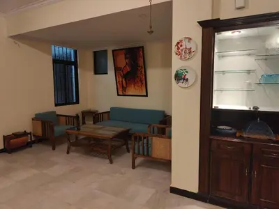 a living room with a blue couch and a table at Thambaratty in Mysore
