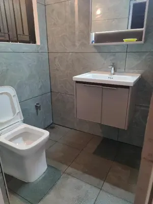 a bathroom with a toilet and a sink at Thambaratty in Mysore