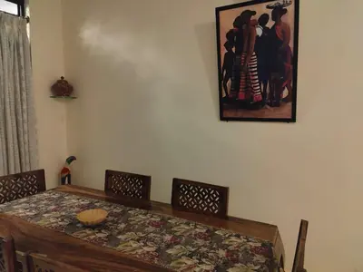 a dining room with a table and a picture on the wall at Thambaratty in Mysore