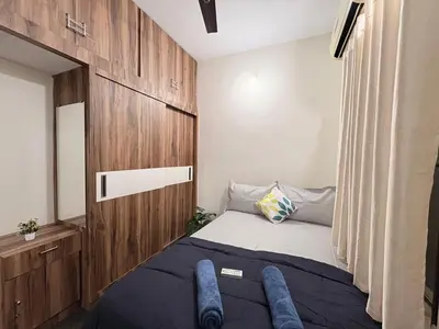 a small bedroom with a bed and a wooden wall at Kamadhenu Homestay, Comapact 1BHK OPP Mysore zoo, in Mysore