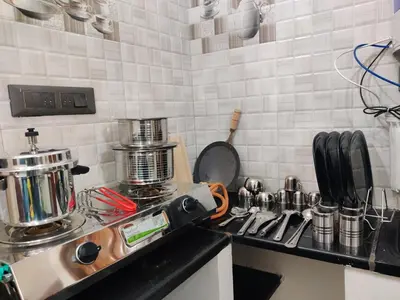a kitchen with a counter top with a stove and a counter top at Kamadhenu Homestay, Comapact 1BHK OPP Mysore zoo, in Mysore
