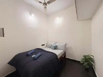 a small bedroom with a bed in a room at Kamadhenu Homestay, Comapact 2BHK OPP Mysore zoo, A in Mysore