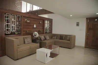 a living room with two couches and a coffee table at Modern 5BR Villa in Thrissur in Trichūr