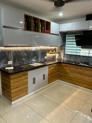 a kitchen with wooden cabinets and a counter top at Modern 5BR Villa in Thrissur in Trichūr