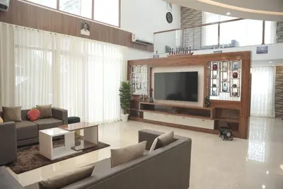 a living room with a couch and a television at Modern 5BR Villa in Thrissur in Trichūr