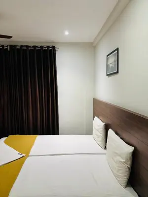 a bedroom with a bed with a wooden headboard at Hotel Malabar Grand in Perintalmanna