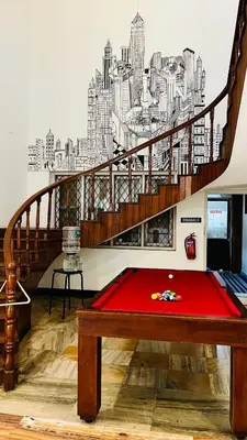 a room with a red table in front of a staircase at LF Easybeds in Kozhikode