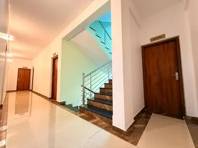 a hallway with a staircase and a wooden door at TREE 9 Lounge -Cochin Airport in Nedumbassery