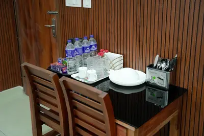 a table with a bottle of water and two chairs at TREE 9 Lounge -Cochin Airport in Nedumbassery
