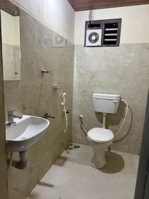 a bathroom with a toilet and a sink at HG Tower 2 in Kunnamangalam