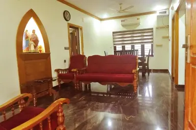 a living room with a red couch and chairs at Niki Haven in Kāladi