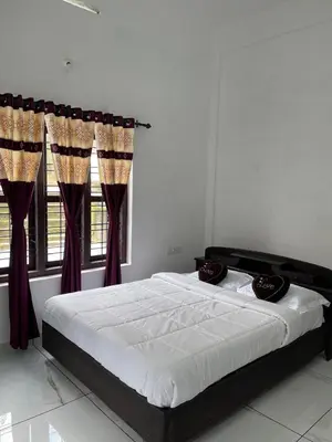 a bedroom with a large bed with red curtains at Wayanad Evergreen Farmhouse in Sultan Bathery