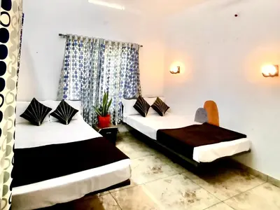 a room with two beds and a chair at Chembani Holidays and Resorts Kanthalloor in Kanthalloor