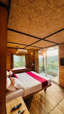 a large bed in a room with a large window at The Crescent Wayanad Heritage Pool Resort in Sultan Bathery
