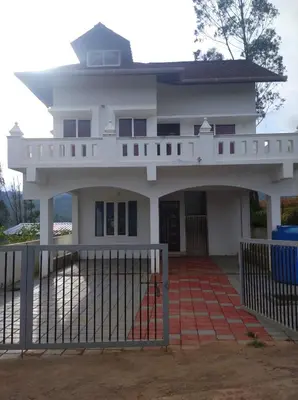 a house with a gate in front of it at White house in Ooty
