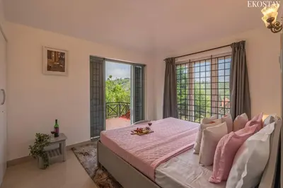 a bedroom with a large bed and a balcony at EKOSTAY - Villa Eve in Ooty