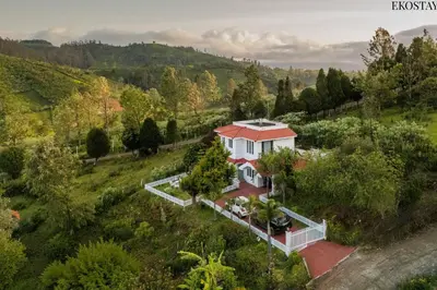 an aerial view of a white house with a red roof at EKOSTAY - Villa Eve in Ooty