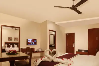 a bedroom with a bed with two swans shaped towels at Bhasuri Inn Guruvayoor in Guruvāyūr