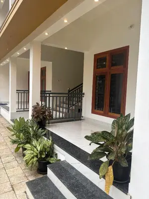 a porch of a house with potted plants at CT HOMESTAY, Omassery in Tāzhekkod