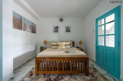 a bedroom with a bed and a blue door at EKOSTAY - Casa Del Sol in Ooty