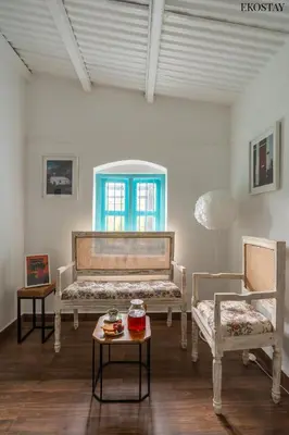 a room with two benches and a table and a window at EKOSTAY - Casa Del Sol in Ooty