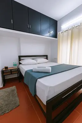 a bedroom with a large bed with blue and white sheets at Country Side Inn in Vayittiri