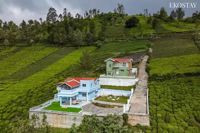 an aerial view of a house in a field at EKOSTAY - Garden Grove Villa in Ooty