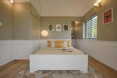 a bedroom with a large white bed in a room at EKOSTAY - Dutch Cottage in Ooty