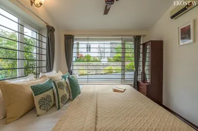 a bedroom with a large bed with a large window at EKOSTAY - Skyfall Cloud 9 Villa in Ooty