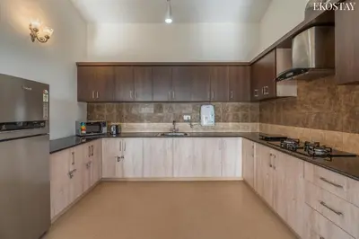 a large kitchen with wooden cabinets and a sink at EKOSTAY - Skyfall Cloud 9 Villa in Ooty