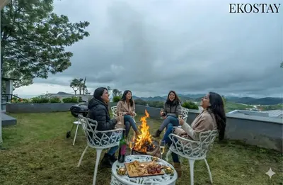 a group of women sitting around a fire at EKOSTAY - Skyfall Mist Villa in Ooty