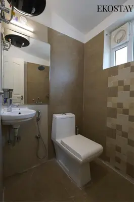 a bathroom with a toilet and a sink at EKOSTAY - Skyfall Elysium Villa in Ooty