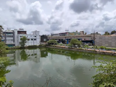 a river in a city with buildings in the background at Queens INN in Kodungallūr