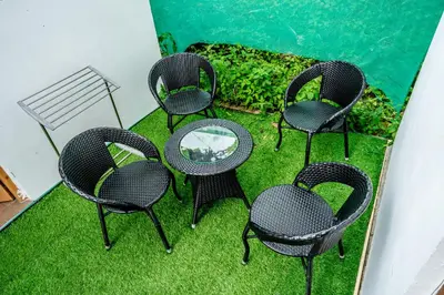 a group of chairs and a table on the grass at Zacs Valley Resort & Wellness Retreat Kodaikanal in Kodaikānāl