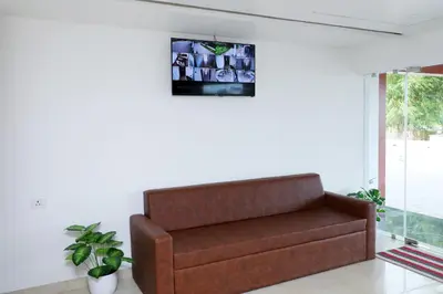 a brown couch in a room with a window at Aura Airport Hotel in Nedumbassery