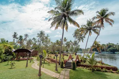 a park with palm trees and a body of water at Madilina Cottage in Parūr