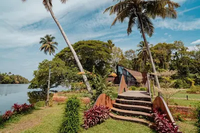 a set of stairs next to a lake with palm trees at Madilina Cottage in Parūr