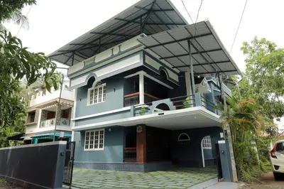 a blue house with a balcony at Prithvi Nila Heavens 3 BHK Homestay Ground Floor in Guruvāyūr