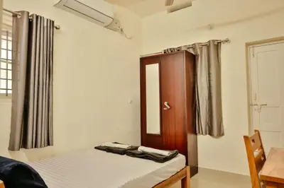 a small bedroom with a bed and a mirror at Prithvi Nila Heavens 3 BHK Homestay Ground Floor in Guruvāyūr