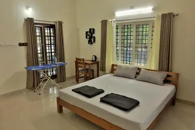 a bedroom with a bed with two pillows on it at Prithvi Nila Heavens 3 BHK Homestay Ground Floor in Guruvāyūr