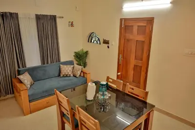 a living room with a couch and a table at Akasha Nila Heavens 2 BHK Homestay - Top floor in Guruvāyūr