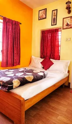 a bedroom with a large bed with red curtains at Winterfell Park in Ooty