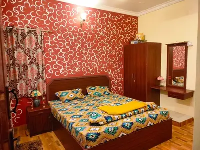 a bedroom with a bed with a red wall at AAK Hills stay villa in Kodaikānāl