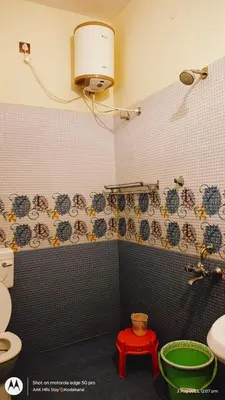 a bathroom with a toilet and a red stool at AAK Hills stay villa in Kodaikānāl