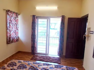 a bedroom with a window and a bed and a door at AAK Hills stay villa in Kodaikānāl