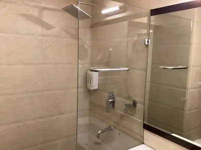 a shower with a glass door in a bathroom at Hotel Atrium in Erode