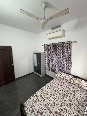 a bedroom with a bed and a ceiling fan at Anchery homes in Trichūr