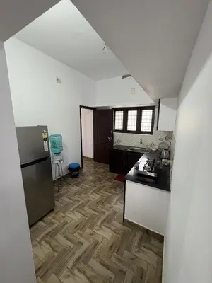 a kitchen with a counter top and a refrigerator at Anchery homes in Trichūr