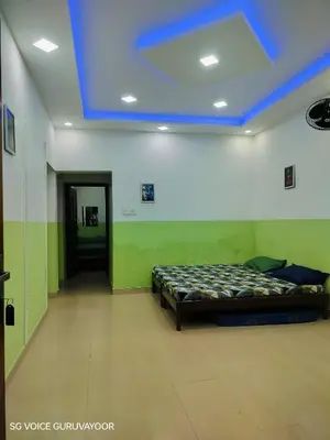a room with a bed and a blue ceiling at Clap House Home in Guruvāyūr