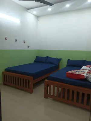 two beds sitting next to each other in a room at Clap House Home in Guruvāyūr